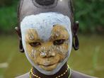 Jihozápadní Etiopie, údolí Omo, Kibish: portrét dívky z kmene Surma, která má obličej nazdobený bílou a žlutou hlinkou (křídou)