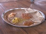Inžara je základní součást etiopské stravy, te to placka s kyselou chutí, ke které podávají různé přílohy.